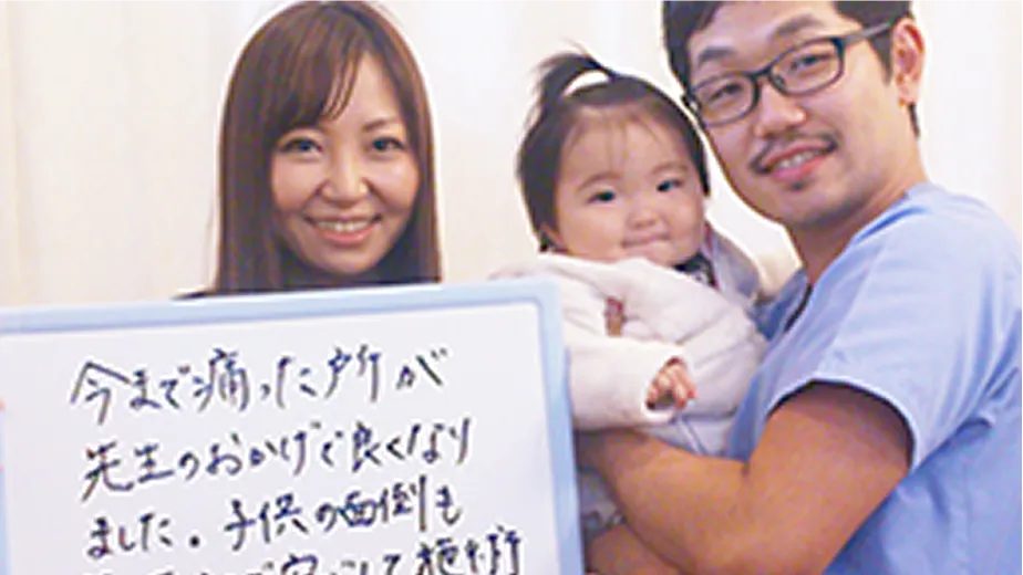 口コミを書いたボードを掲げる女性と子供と男性