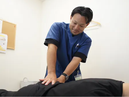 男性患者の腰を施術する男性施術者の様子